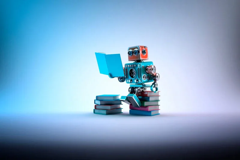 Robot di atas tumpukan buku Gambar dari "3 Chatbot Shopify teratas di tahun 2021" Artikel